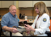 Veteran Leonard Englebrook and VA New Jersey Health Care System Nurse Margaret Hogan, RN, review the use of a cell phone for Telehealth.